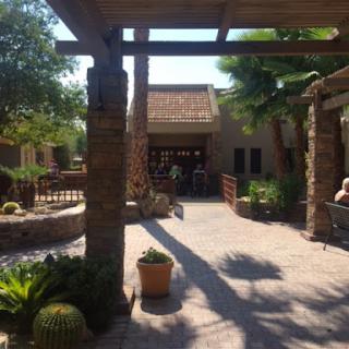 A serene courtyard with stone features and lush greenery, basking in the sunlight.