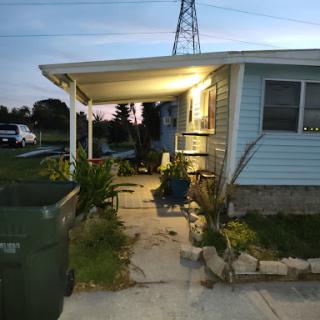 A cozy residential home with a lit porch, seen during the evening.