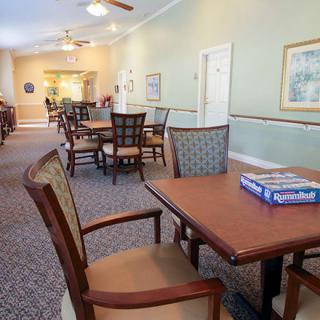 A spacious dining and recreational area with tables and chairs, featuring a board game ready for play.