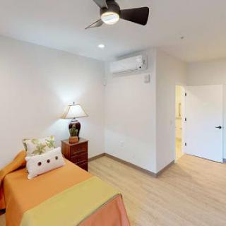 A cozy and modern bedroom featuring a comfortable bed, stylish decor, and essential amenities.