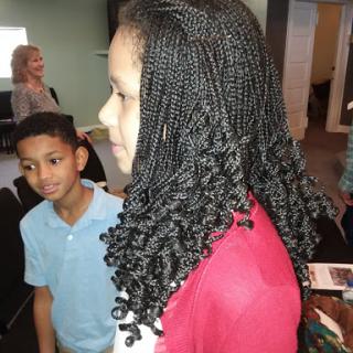 Two children engaging in a moment, showcasing beautiful braided hairstyle.