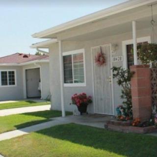 A peaceful residential home with a well-maintained front yard and flower pots.