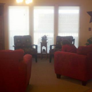 A cozy living room with a seating arrangement facing large windows.