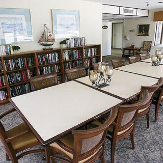 A well-organized library and meeting room with bookshelves, a conference table, and chairs.