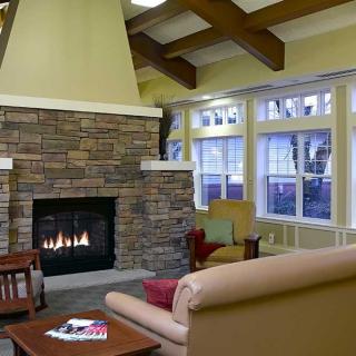 A cozy living room with a stone fireplace and comfortable seating.