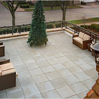 A spacious patio area featuring elegant outdoor furniture and a decorative tree.