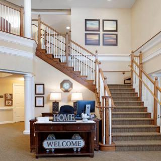 A cozy interior featuring a staircase and a reception desk with welcoming decor.