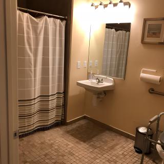 A cozy bathroom with a shower, sink, and mirror.
