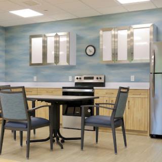 A modern kitchen and dining area featuring a table with chairs, an oven, and a refrigerator.