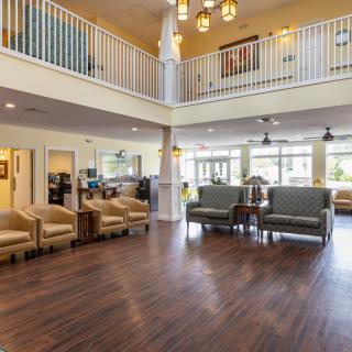 A spacious and modern lobby with wooden floors, featuring comfortable seating areas.