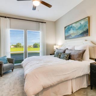 A cozy bedroom with a large bed, natural light from windows, and tasteful decor.