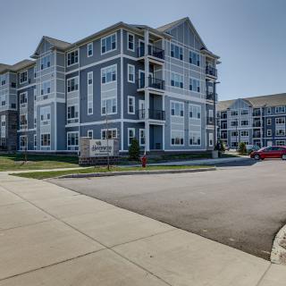 A modern apartment building complex in an urban area on a sunny day.