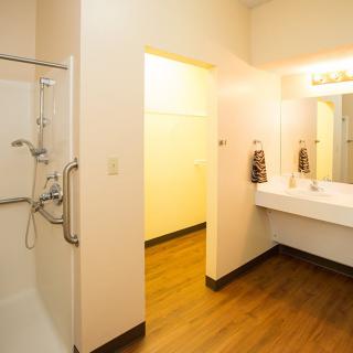 A modern bathroom with a spacious shower and a large sink area.