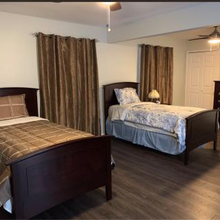 A cozy bedroom featuring two single beds with wooden frames and matching curtains.