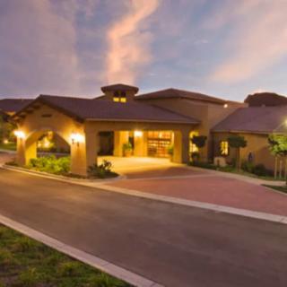 A beautifully lit house exterior at dusk with a spacious driveway.