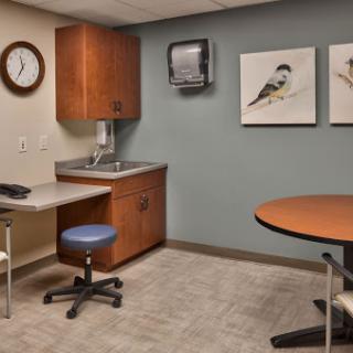 A calm and organized medical office waiting area, featuring modern furniture and bird artwork on the walls.