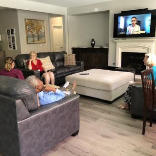 A group of people sitting in a living room watching television.
