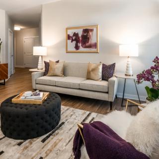 A modern living room featuring a neutral-toned sofa, stylish lamps, and contemporary artwork.