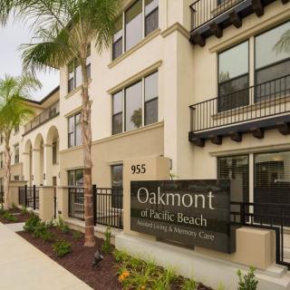 Exterior view of Oakmont of Pacific Beach senior living facility with palm trees.