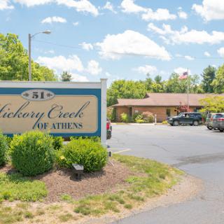 Entrance to Hickory Creek at Athens, featuring a welcoming sign and landscaped area.
