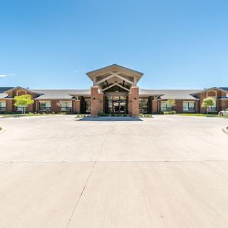 A welcoming entrance to a modern commercial building under a bright blue sky.