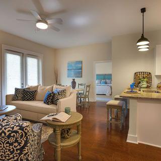 A cozy and modern living space featuring a comfortable sofa, stylish furniture, and an open kitchen with pendant lighting.