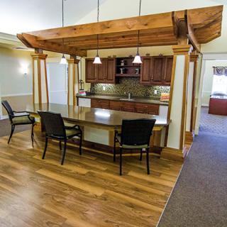 A modern kitchen and dining area with wooden furniture and pendant lighting.