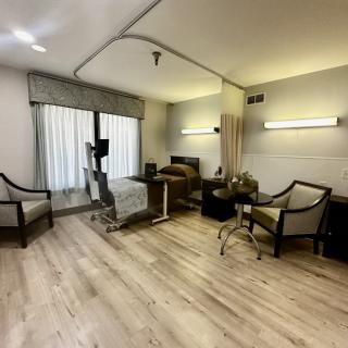 A modern hospital room with medical equipment and comfortable seating.