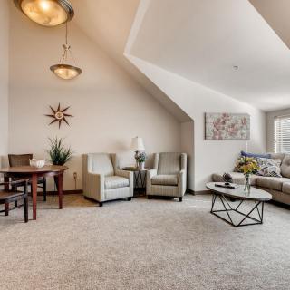 A modern living room with a cozy seating area, stylish furniture, and a dining table.