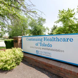 A sign for Continuing Healthcare of Toledo in a landscaped setting.