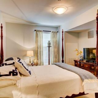 A cozy bedroom with a four-poster bed, elegant decor, and modern amenities.