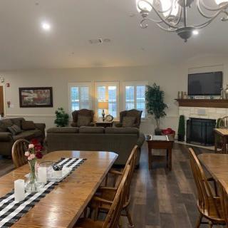Spacious open-plan living and dining area with cozy seating, a fireplace, and elegant decor.