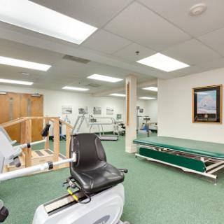 A well-equipped rehabilitation gym featuring exercise machines and a spacious training area.