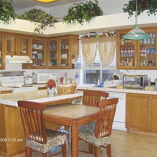 A cozy kitchen with wooden cabinets, an island counter, and various appliances.