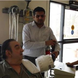 A doctor checking a patient's blood pressure in a medical setting.