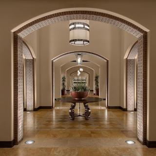 A beautifully designed hallway featuring arched entrances and warm lighting.