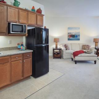 An open-concept kitchen and living area with modern appliances and cozy seating.