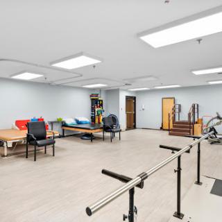 A spacious therapy room equipped for rehabilitation exercises.