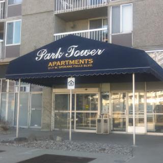 The entrance to Park Tower Apartments, featuring a blue awning.