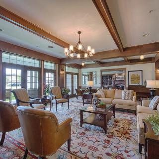 Spacious living room with elegant furniture and a large chandelier.
