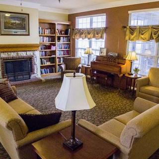A cozy living room featuring comfortable sofas, a fireplace, and a bookshelf.