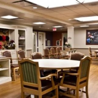 A cozy dining area with several tables and chairs, well-lit and neatly arranged.
