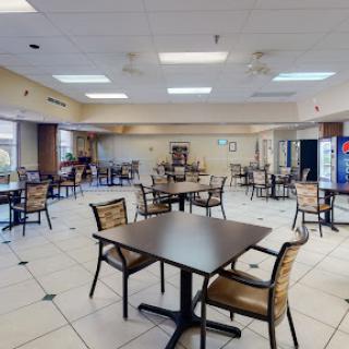 An empty dining area featuring tables and chairs, ready for patrons.