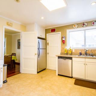 A modern kitchen featuring a refrigerator, dishwasher, and ample cabinet space with natural lighting.