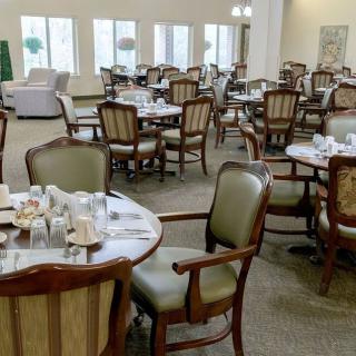 A neatly arranged dining room with tables and chairs, ready for service.