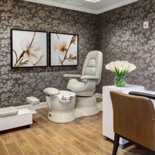 A luxurious spa setting featuring a pedicure chair and elegant floral decor.