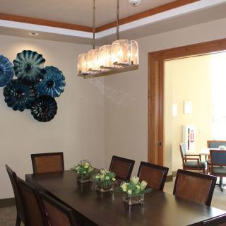 A modern dining room featuring a contemporary chandelier and decorative wall art.