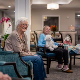 A cozy gathering of seniors enjoying each other's company in a well-lit living area.