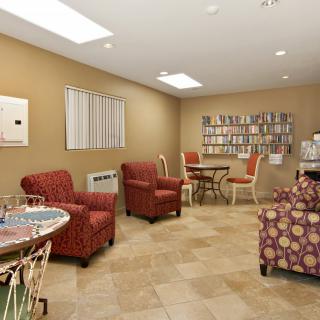 A cozy living room with comfortable armchairs and a bookshelf filled with books.