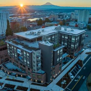 A beautiful sunrise over a cityscape featuring an urban building with a distant mountain view.